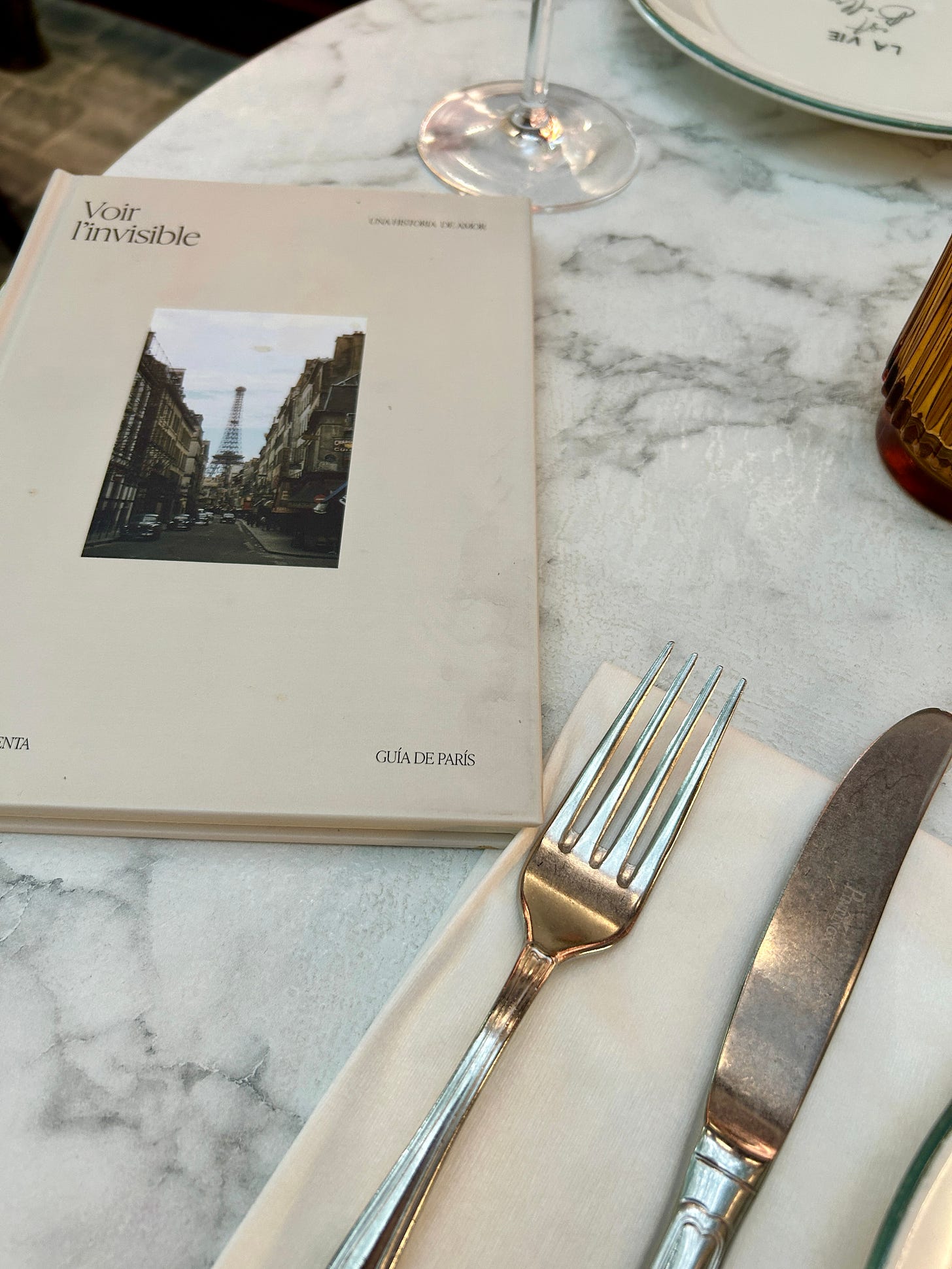 Detalle de la mesa de Voltereta París con su libro sobre la historia en la que se inspira el restaurante Detalle de la mesa de Voltereta París con su libro sobre la historia en la que se inspira el restaurante