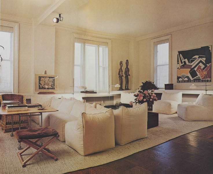 This may contain: a living room filled with lots of white furniture