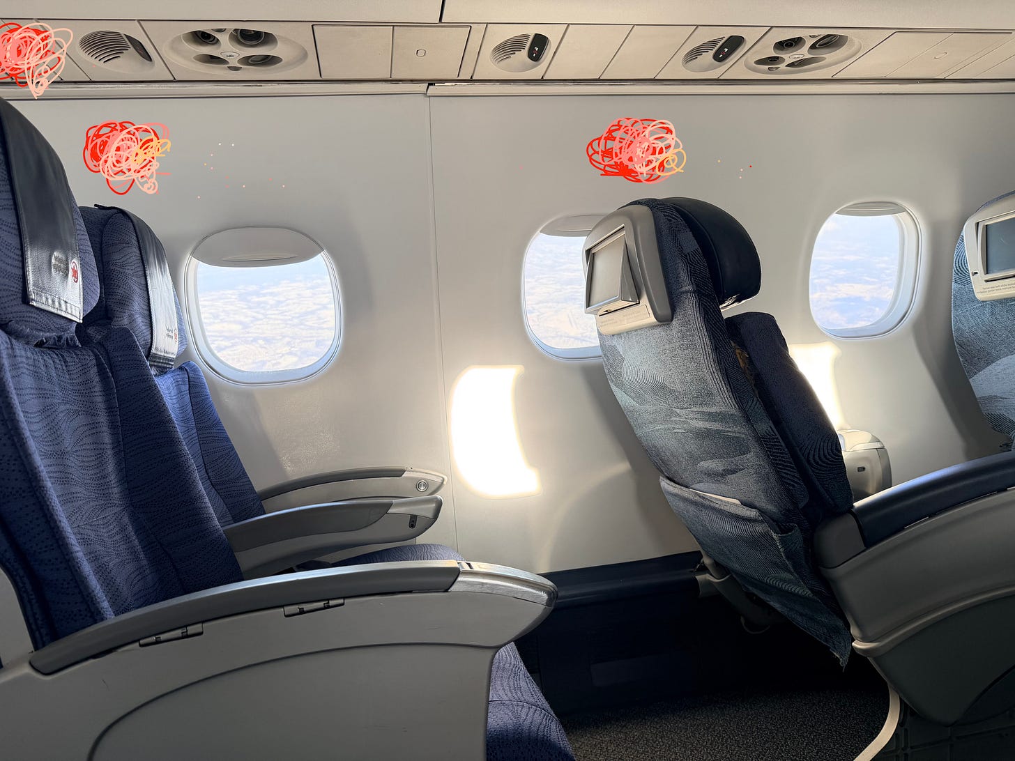 airplane showing three empty seats and squiggles above them