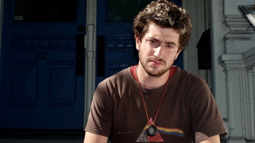 man wearing Friend AI hardware neckpiece man wearing Friend AI hardware neckpiece