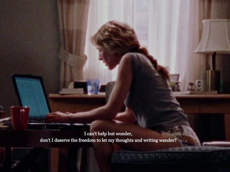 This may contain: a woman sitting at a table with a laptop computer in her lap and looking down