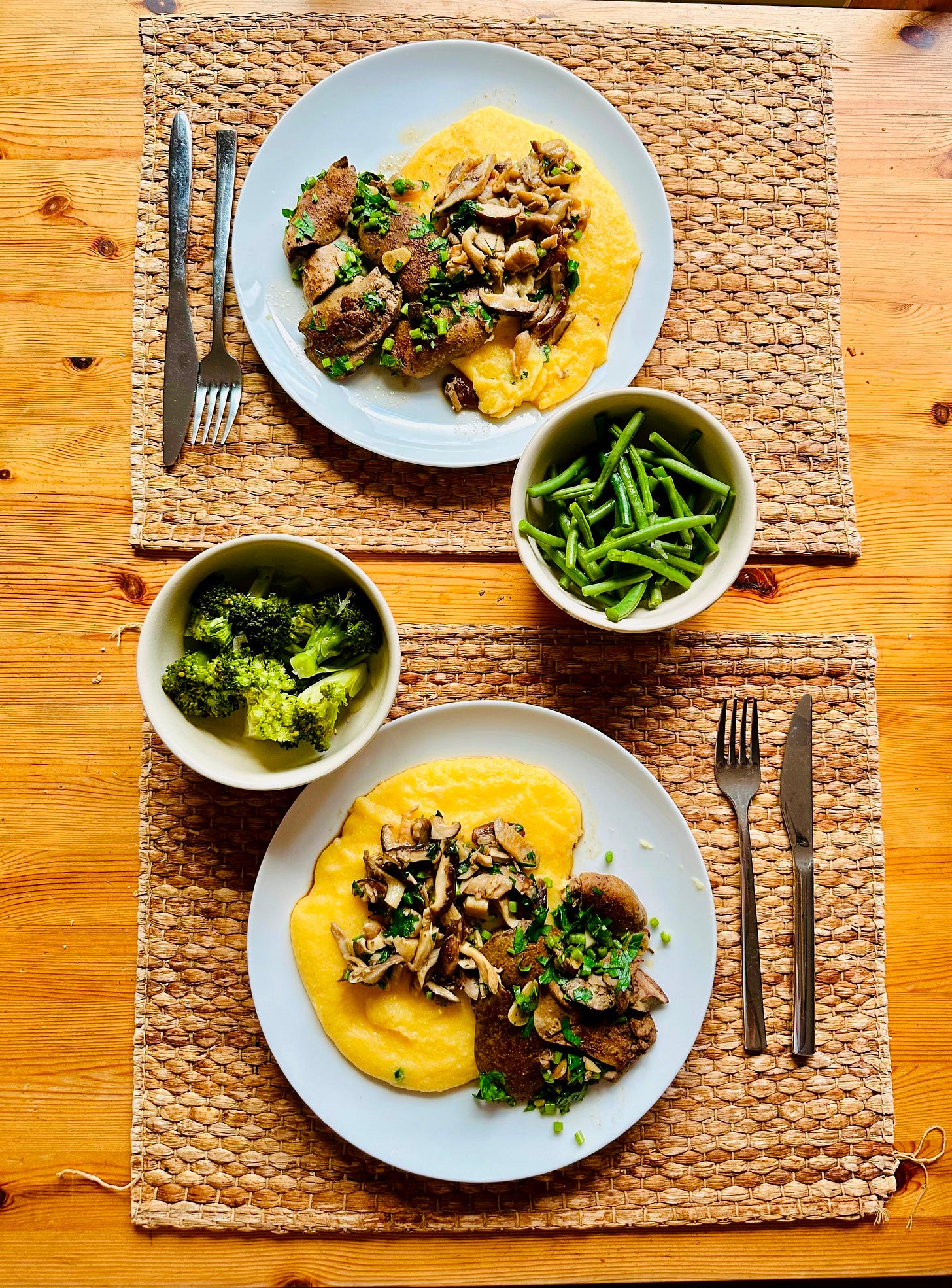 Overhead plate of creamy polenta topped with browned duck livers, sautéed mushrooms, and bright green beans/broccoli
