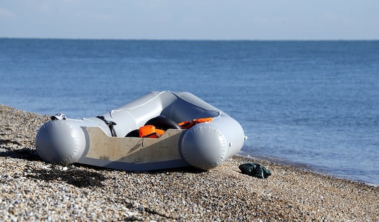 A small rubber dinghy on a beach in England A small rubber dinghy on a beach in England