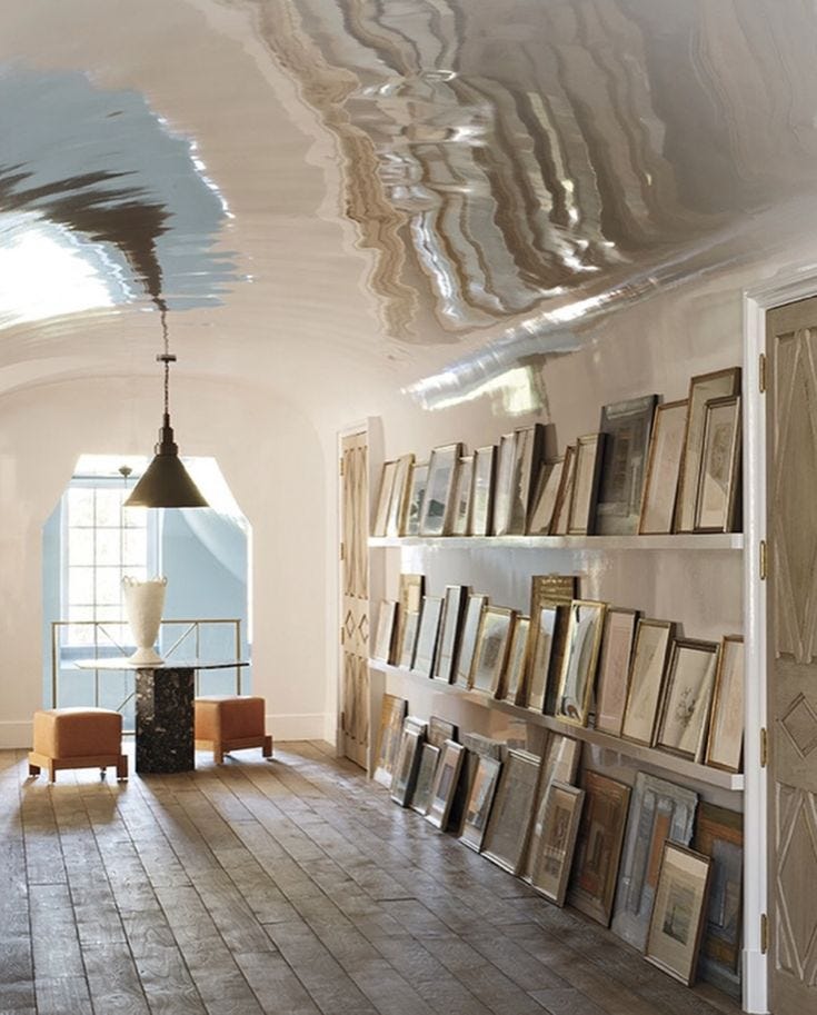 This may contain: a room filled with lots of framed pictures next to a wall full of bookshelves