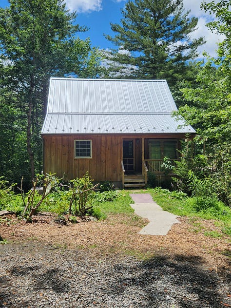Photos of the WoolTribe Studio Cabin renovation project, showing a cabin with new standing seam metal roof, as well as interior shots of the studio with new drop ceiling tiles.