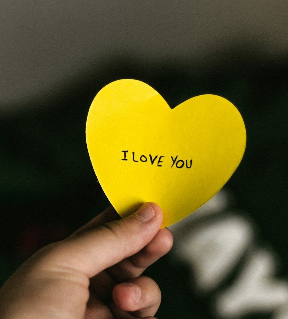 person holding yellow heart paper