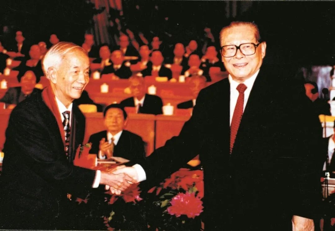 Wang Xiji receiving the ‘Two Bombs, One Satellite’ Merit Award in September 1999 from President Jiang Zemin. Wang Xiji receiving the ‘Two Bombs, One Satellite’ Merit Award in September 1999 from President Jiang Zemin.