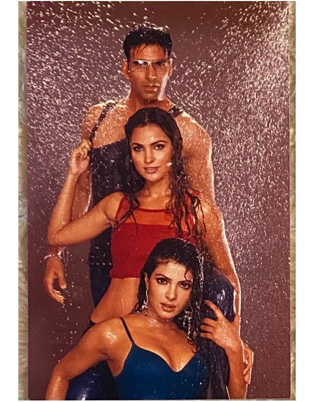 This may contain: two women and a man standing in front of a shower with water splashing on them