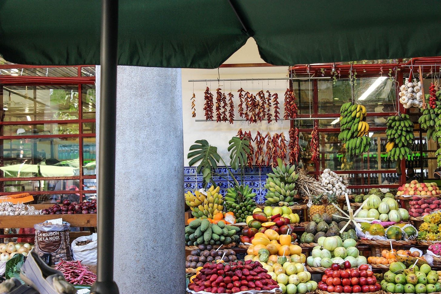 Fresh produce at an outdoor Canadian-style market with bananas, garlic, and tropical fruits
