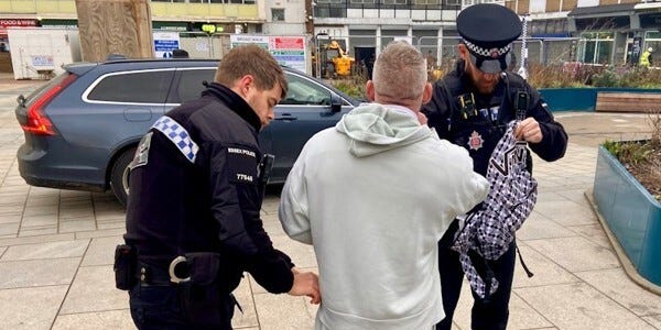 A man is searched following his arrest after being spotted using live facial recognition technology