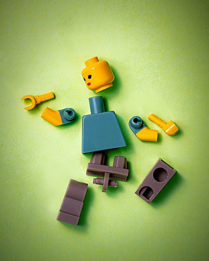 A lego person broken into pieces and left scattered on the floor. A lego person broken into pieces and left scattered on the floor.
