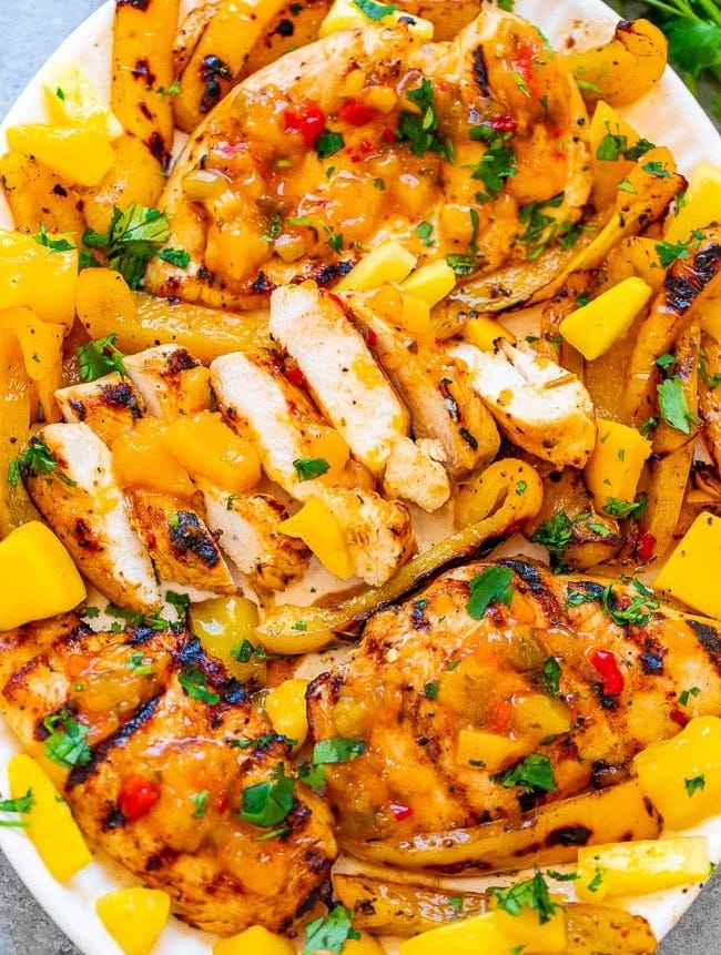 Grilled Mango Pineapple Chicken - EASY, ready in 10 minutes, and the flavor of the juicy chicken makes you feel like you're on a TROPICAL island!! Grilled peppers on the side makes for the PERFECT summer meal that's HEALTHY and DELICIOUS!!
