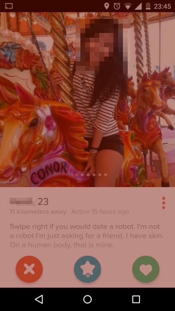 blurred photo of a woman on a carousel as part of her tinder profile, where she indicates that she's definitely not a robot via a joke about wearing human skin