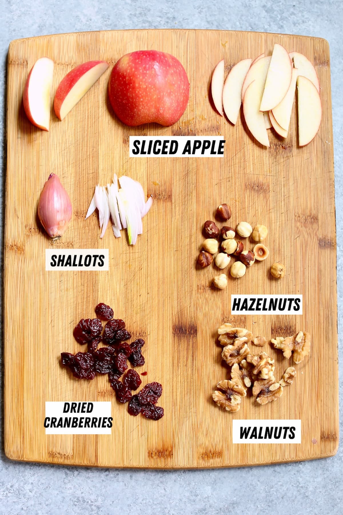 a cutting board with ingredients for a salad.