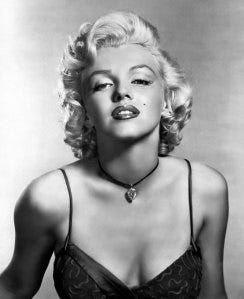 A person with blonde hair wearing a black dress

Description automatically generated