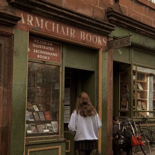 This may contain: a woman standing in front of a book store