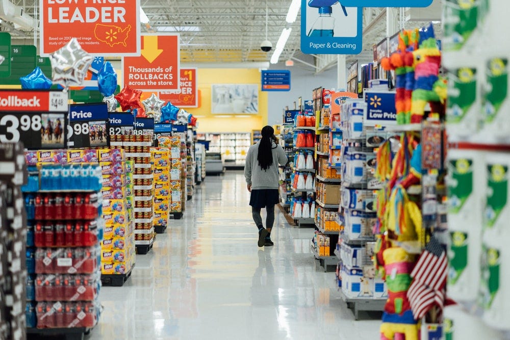 person standing between shelvings person standing between shelvings