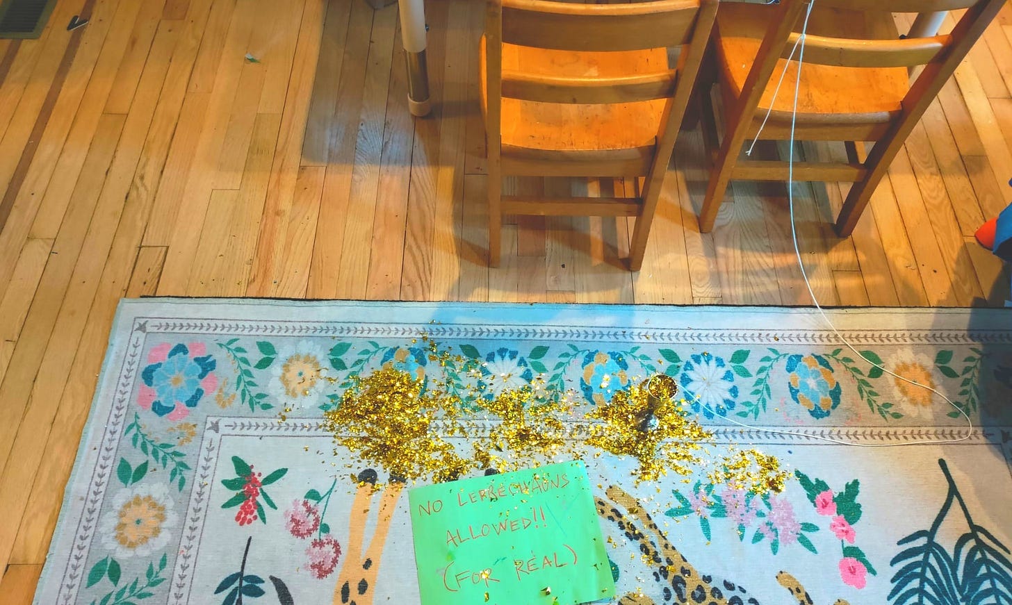 Gold glitter spilled on the floor atop a paper sign that reads: No Leprechauns Allowed (For Real)