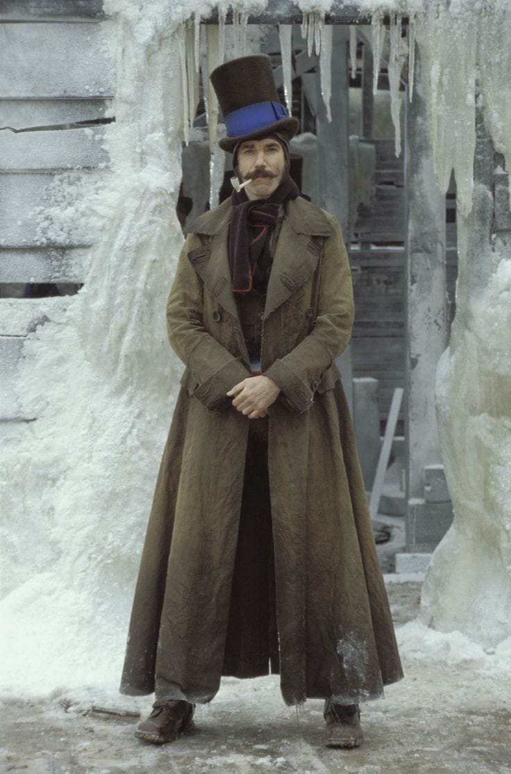 This may contain: a man wearing a top hat and trench coat standing in front of ice covered steps