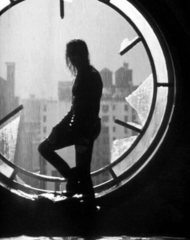 This may contain: a person standing in front of a clock with the image of a woman on it