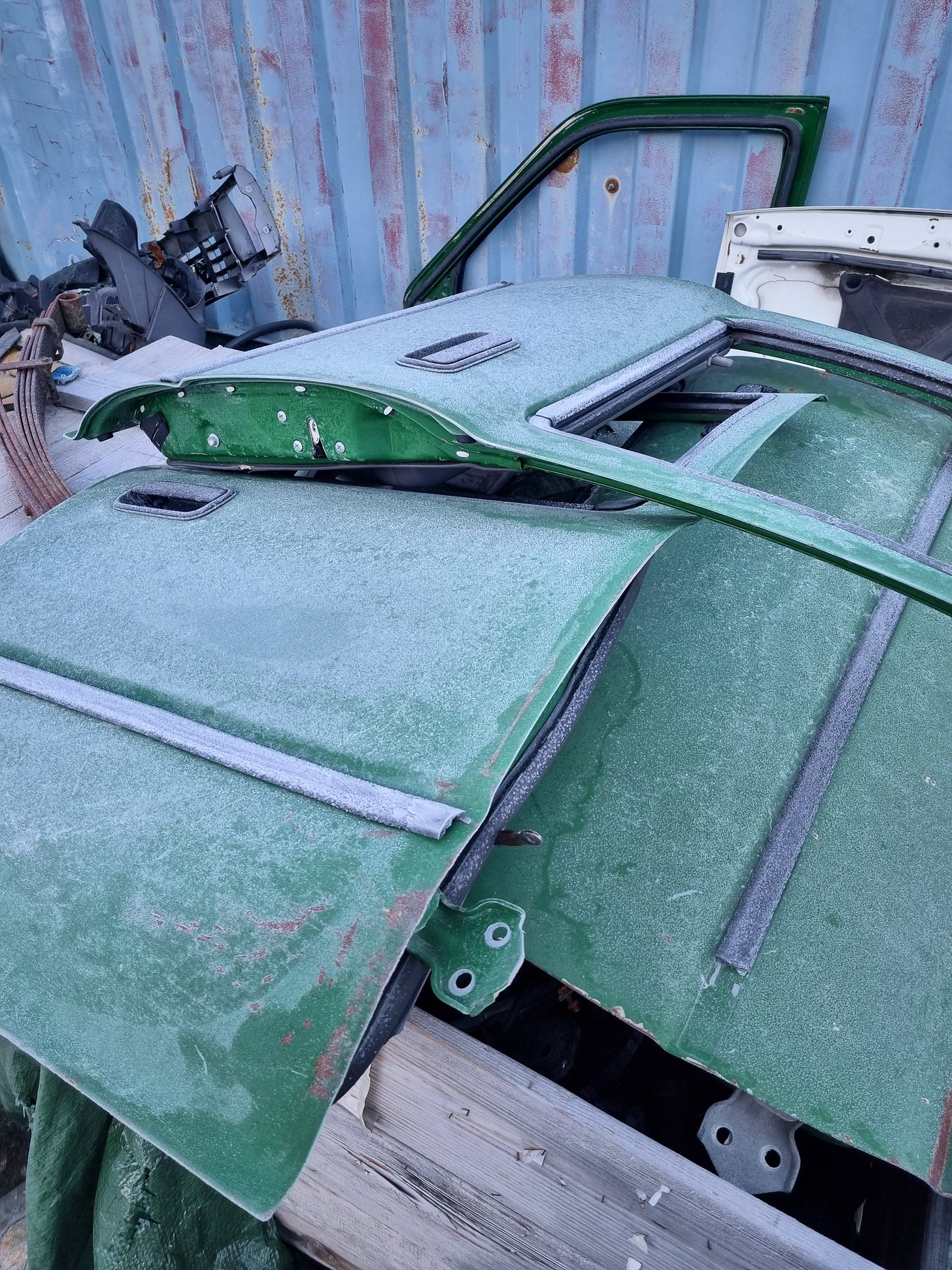 Pile of green car doors covered in frost