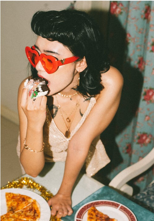 Photo of woman in red heart sunglasses eating cake