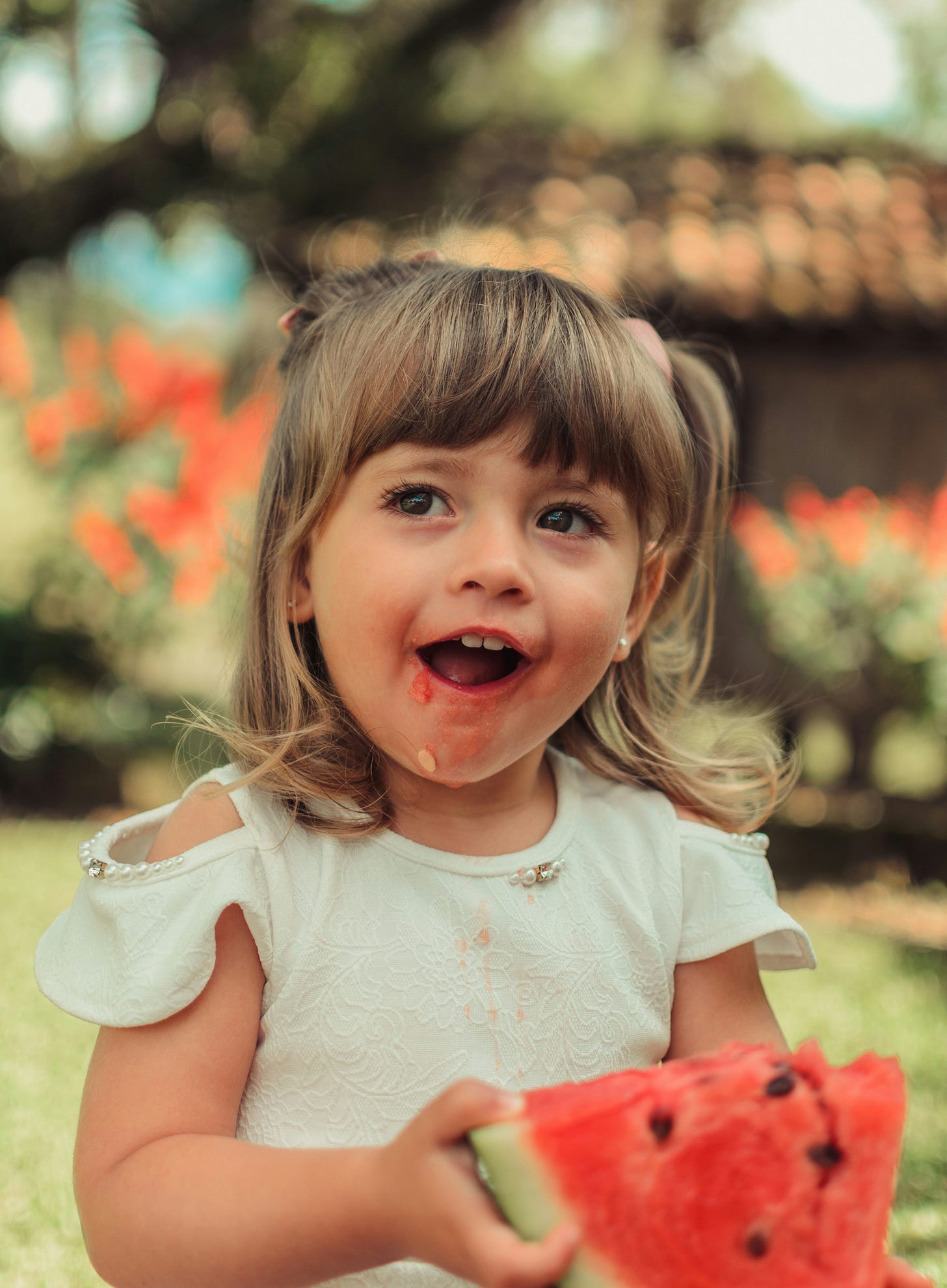 photo of young girl eating watermelon 