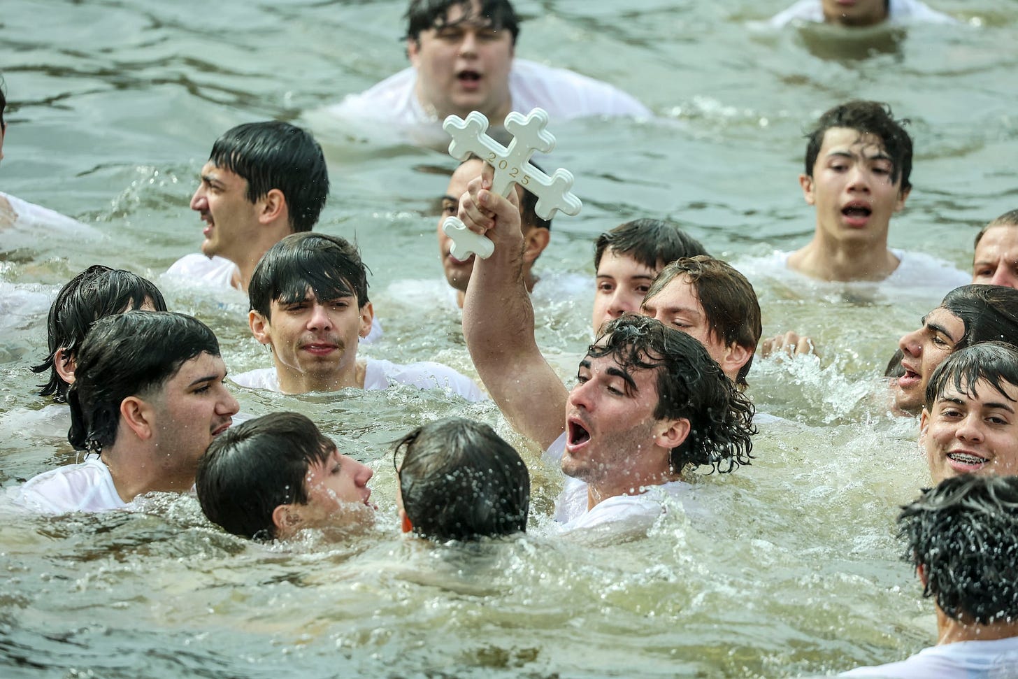 Luc Boillot, 17, of Plantation, emerges from Spring Bayou with the Epiphany cross during the 119th Epiphany Celebration on Monday, Jan 6, 2025, in Tarpon Springs.