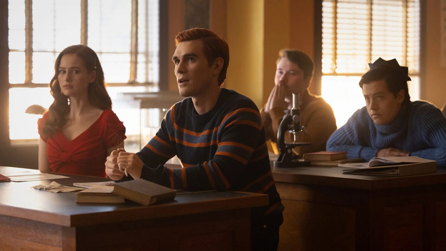 Four students all looking different degrees of uncomfortable in a classroom