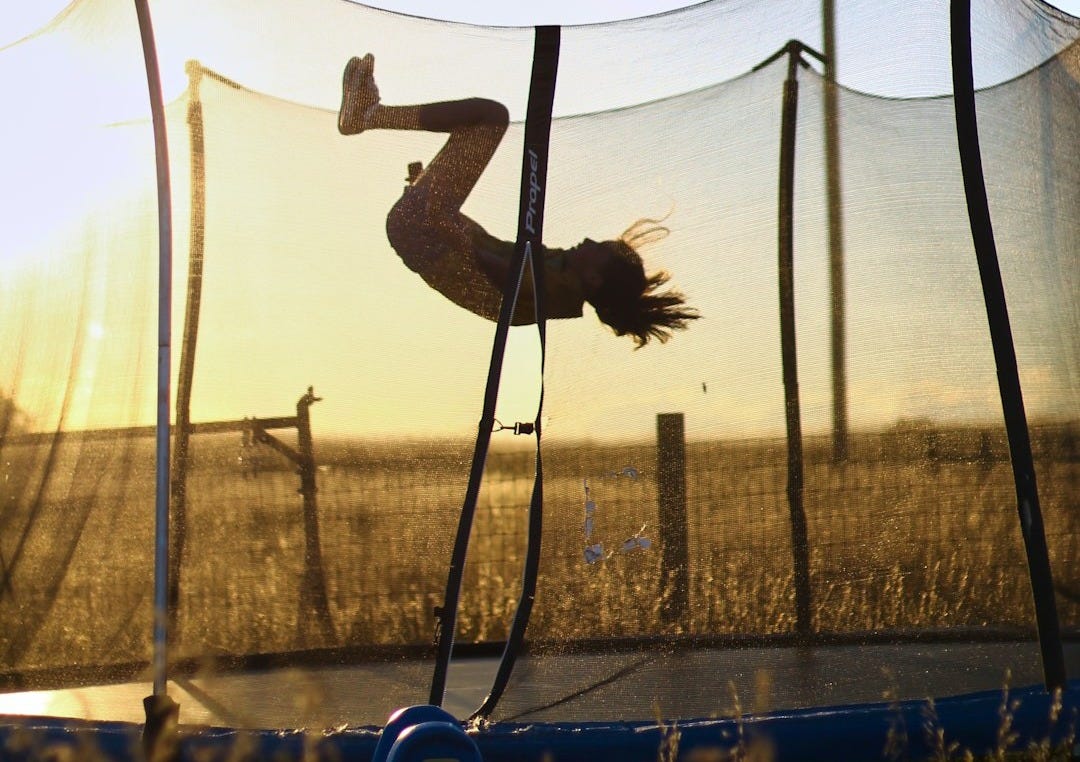 A person is doing a trick on a trampoline