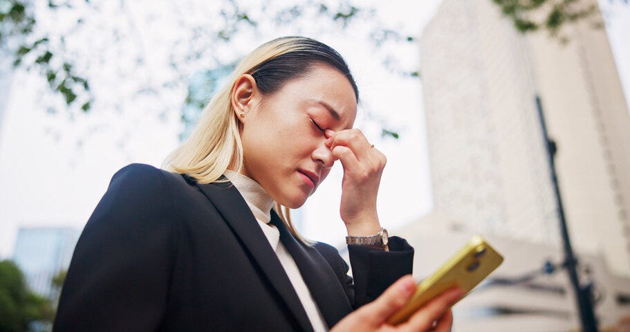 Frustrated, asian woman or phone with headache in city for company bankruptcy, debt or mistake. Japan, female person or employee with migraine or mobile smartphone in strain, financial crisis or fail