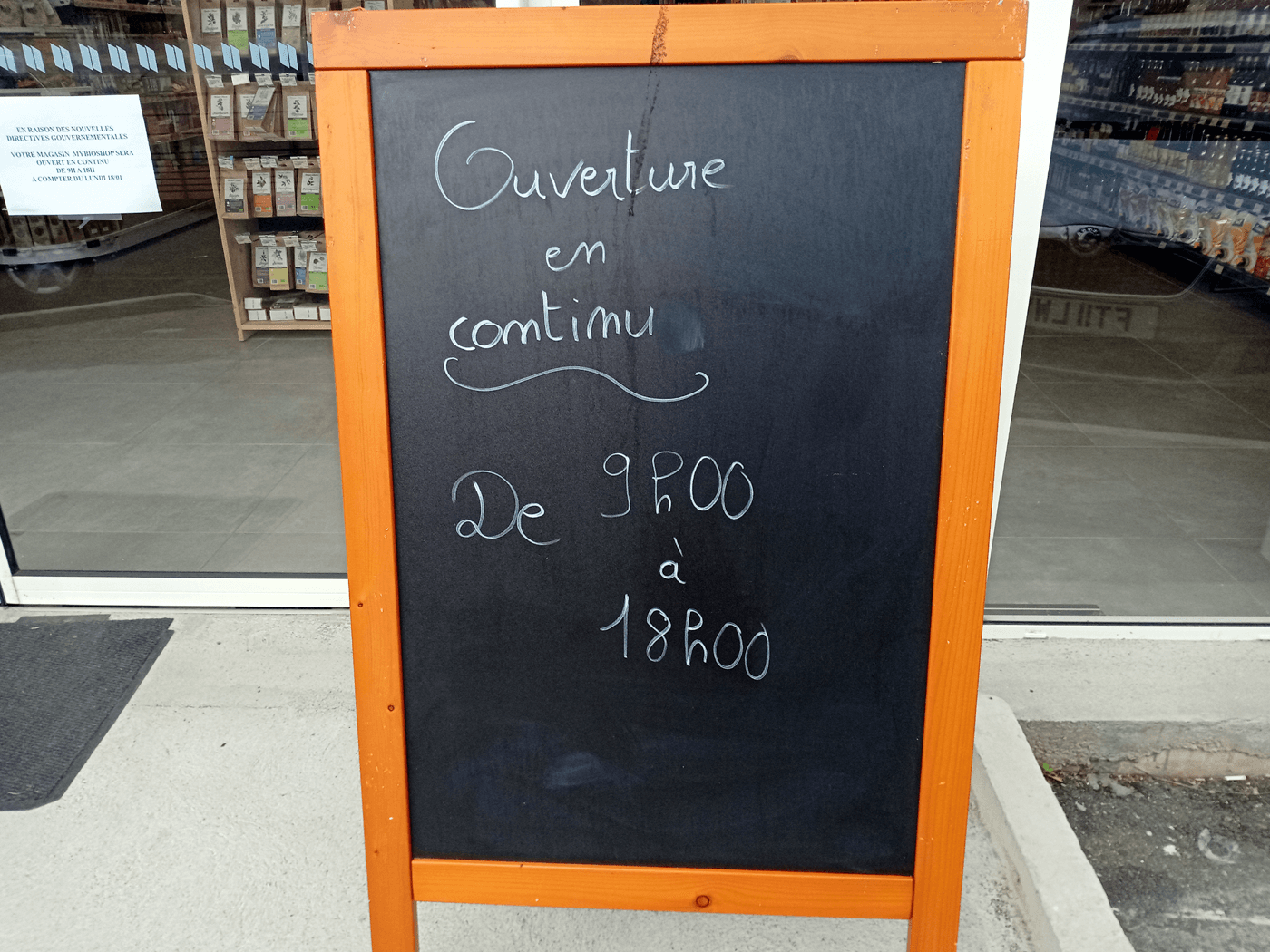 An opening times sign outside a shop: © Chris Aspinall, 2021