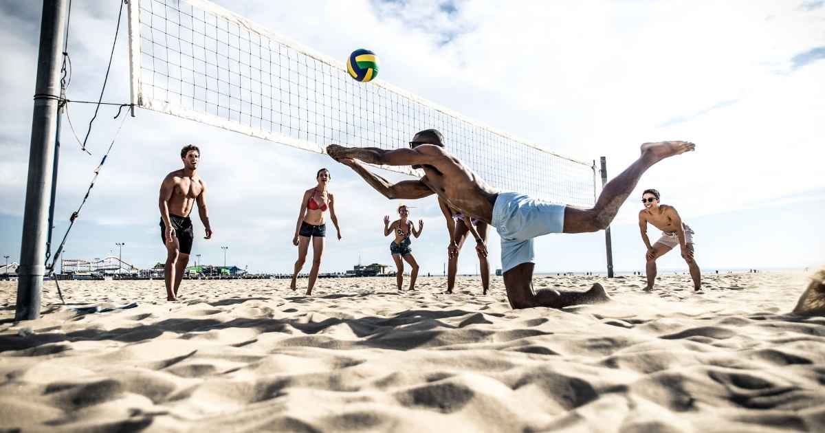 group of friends playing beach volley
