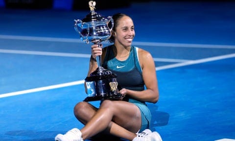 Madison Keys sits on court with the Australian Open trophy