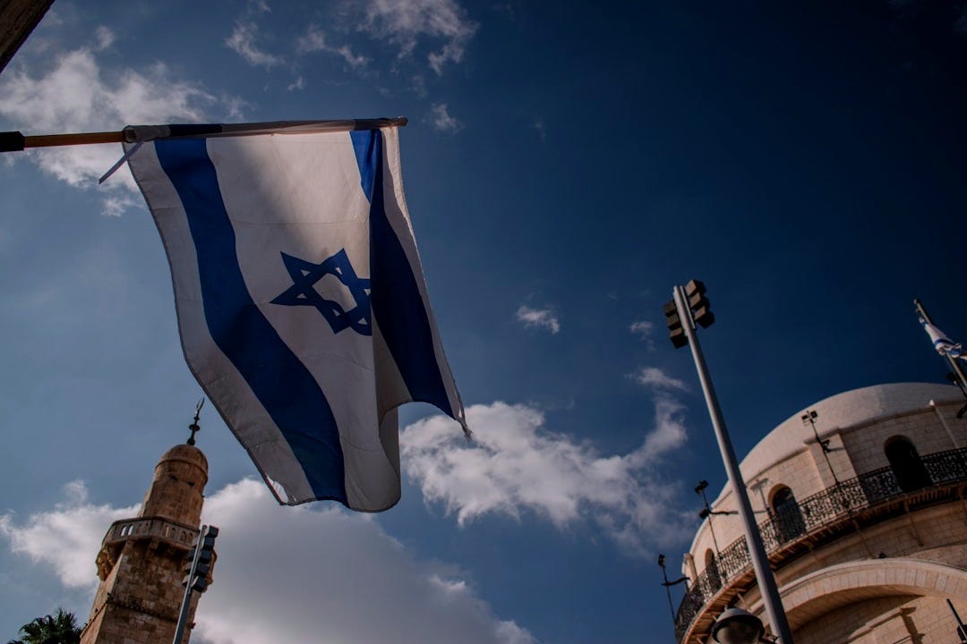 a flag flying in the wind in front of a building a flag flying in the wind in front of a building