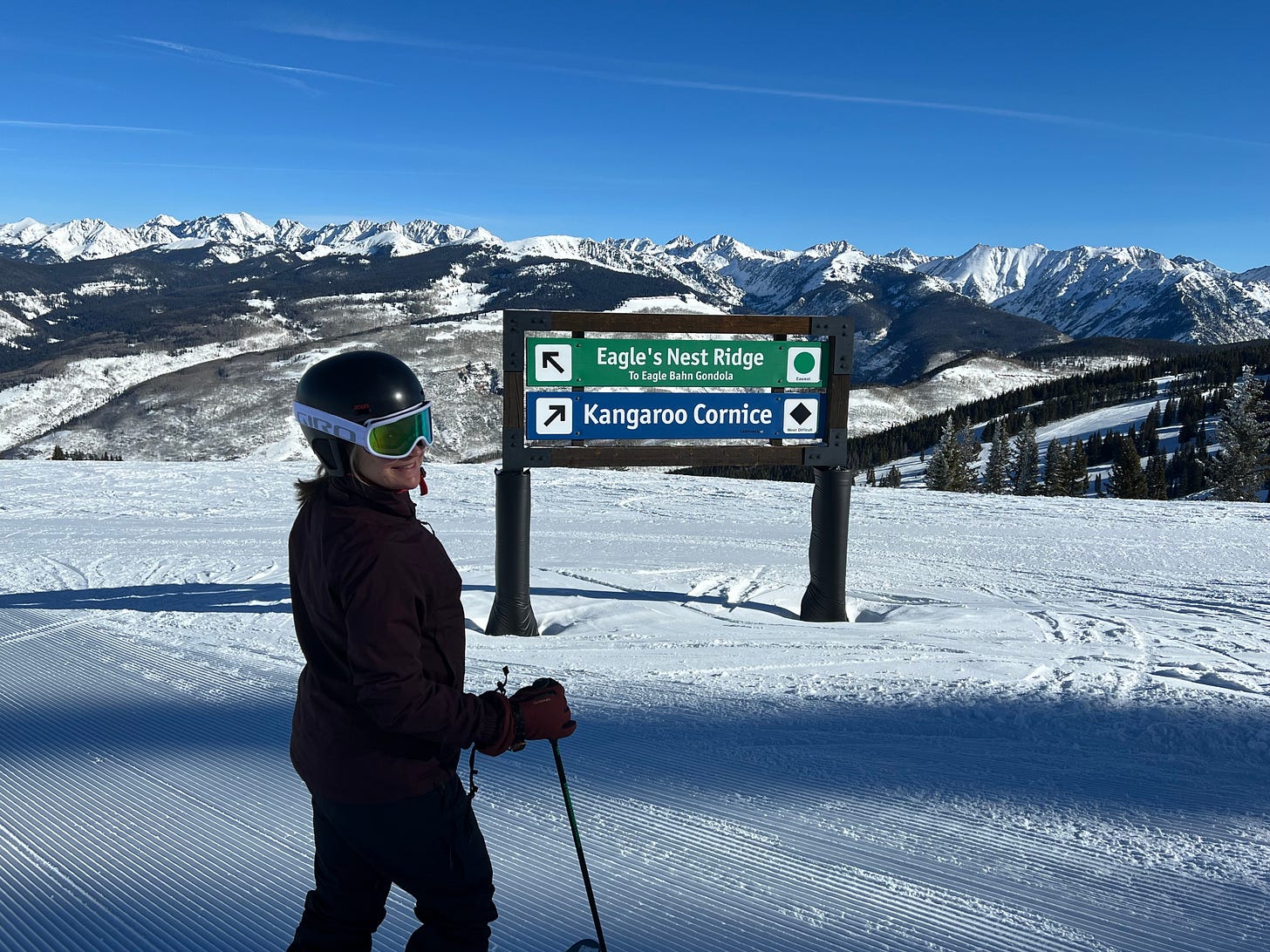 A woman stands on a ski slope