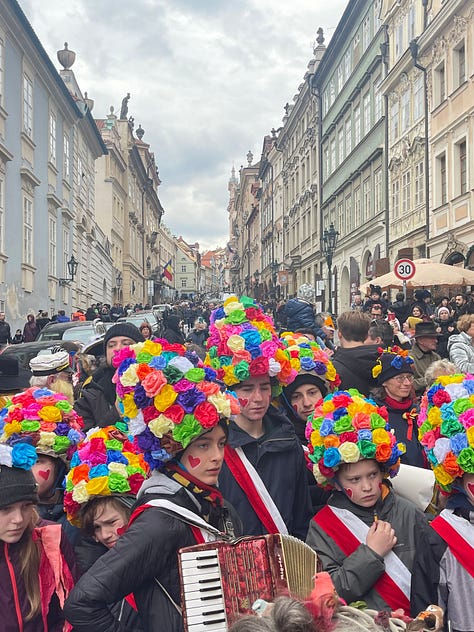 Masked figures in fur and straw costumes during Prague's Masopust, the Czech pre-Lenten carnival.