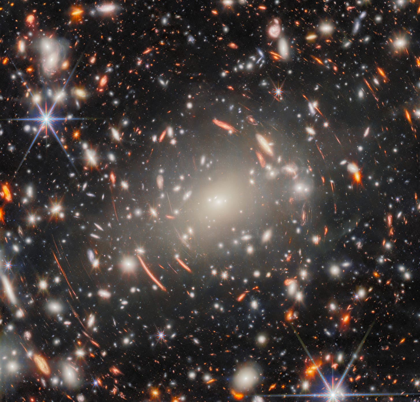 A dense field of distant galaxies, with bright stars and orange arcs of light, illustrates gravitational lensing in deep space, as the JWST reveals new details about our universe. A dense field of distant galaxies, with bright stars and orange arcs of light, illustrates gravitational lensing in deep space, as the JWST reveals new details about our universe.