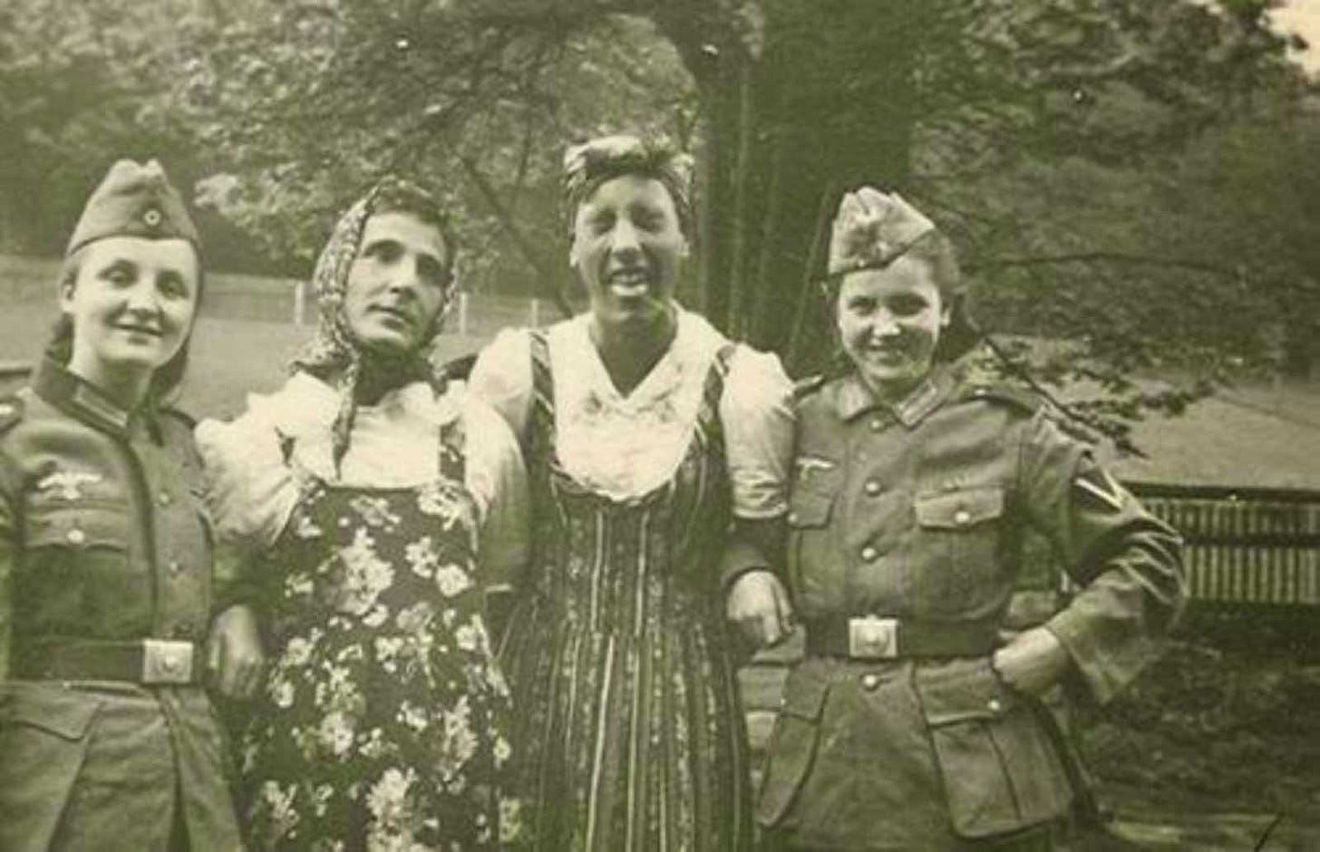 German soldiers playfully exchanging uniforms with their girlfriends, blurring lines during the occupation. German soldiers playfully exchanging uniforms with their girlfriends, blurring lines during the occupation.