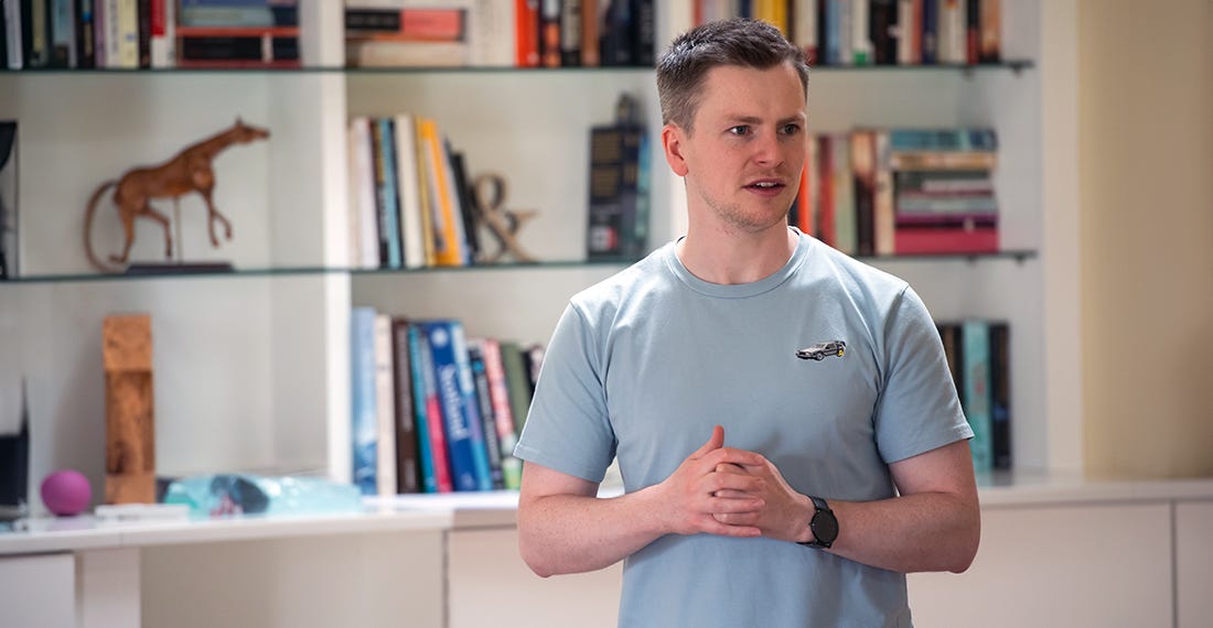 A young man in a blue t-shirt presenting his ideas