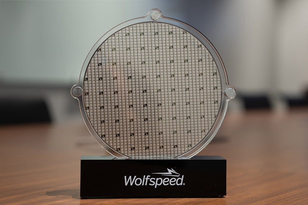 Close up product photo of a silicone carbide wafer and branded stand. Close up product photo of a silicone carbide wafer and branded stand.