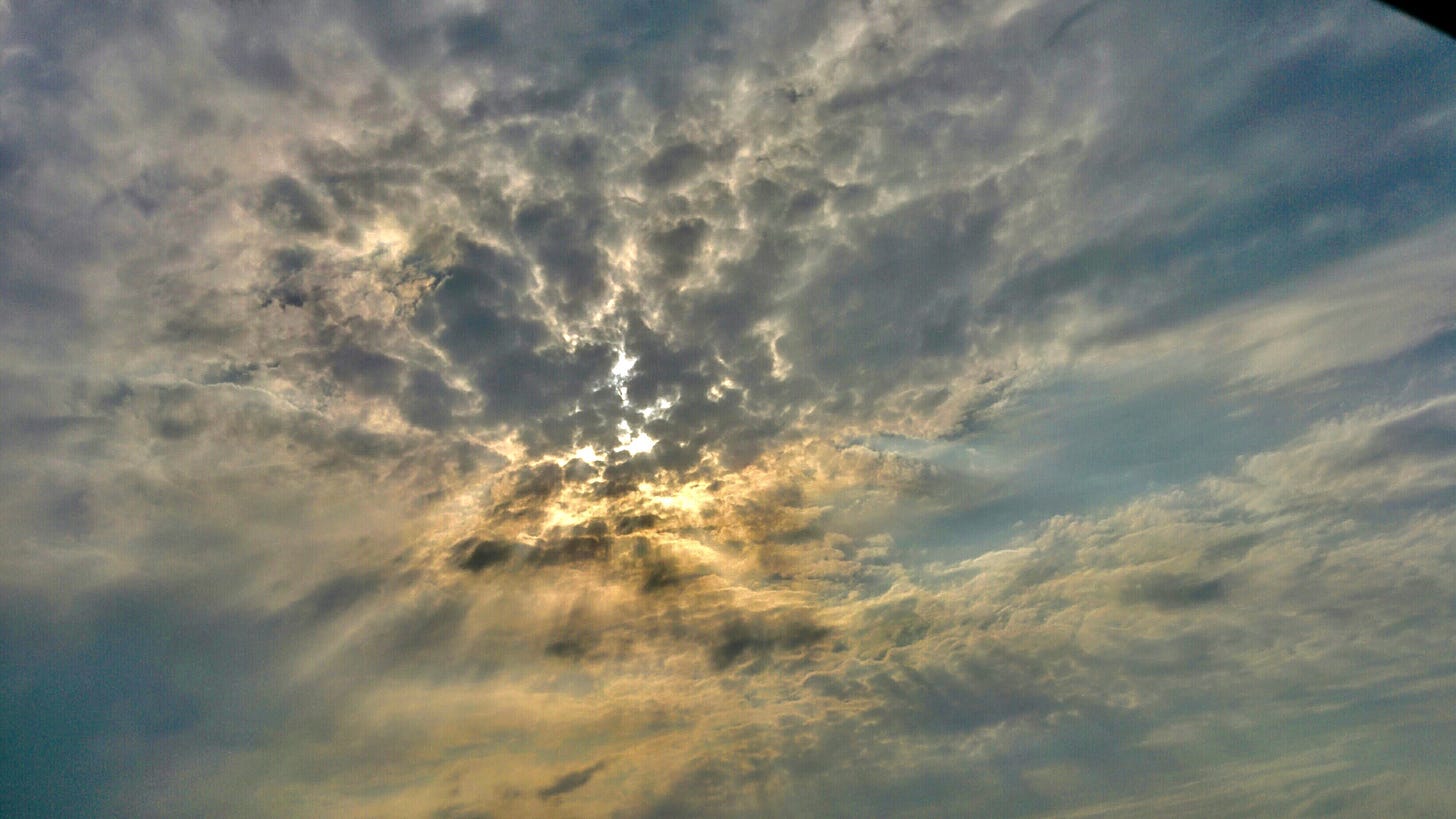 Photo of a cloudy sky with sun rays penetrating it dramatically resembling Dark Souls sky