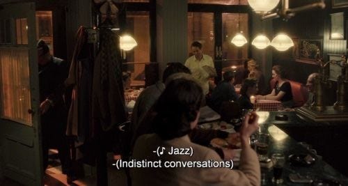 This may contain: people are sitting at a bar in a dimly lit room with lights hanging from the ceiling