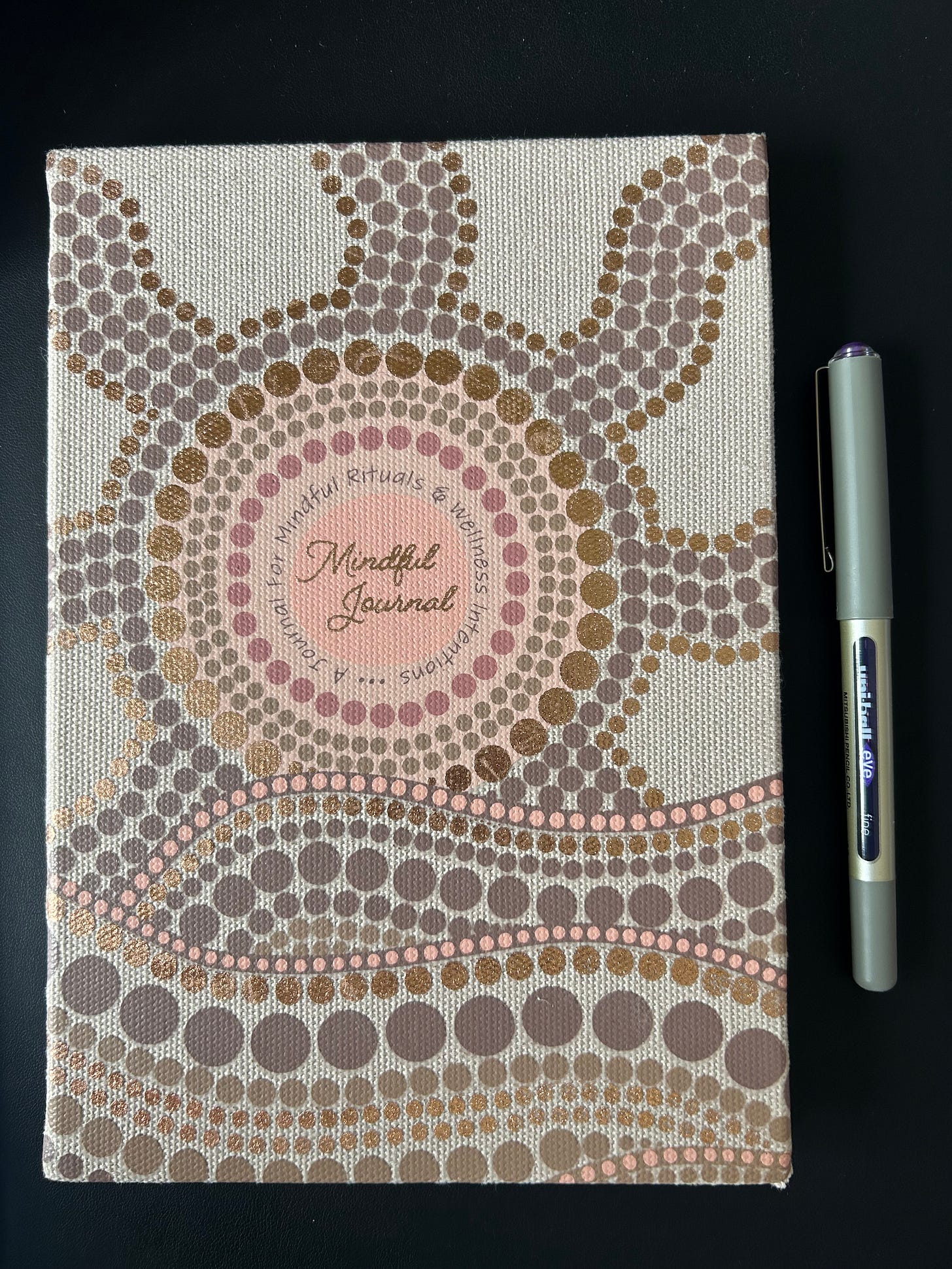 The front of a journal that has an Aboriginal dot painting design. The front of a journal that has an Aboriginal dot painting design.