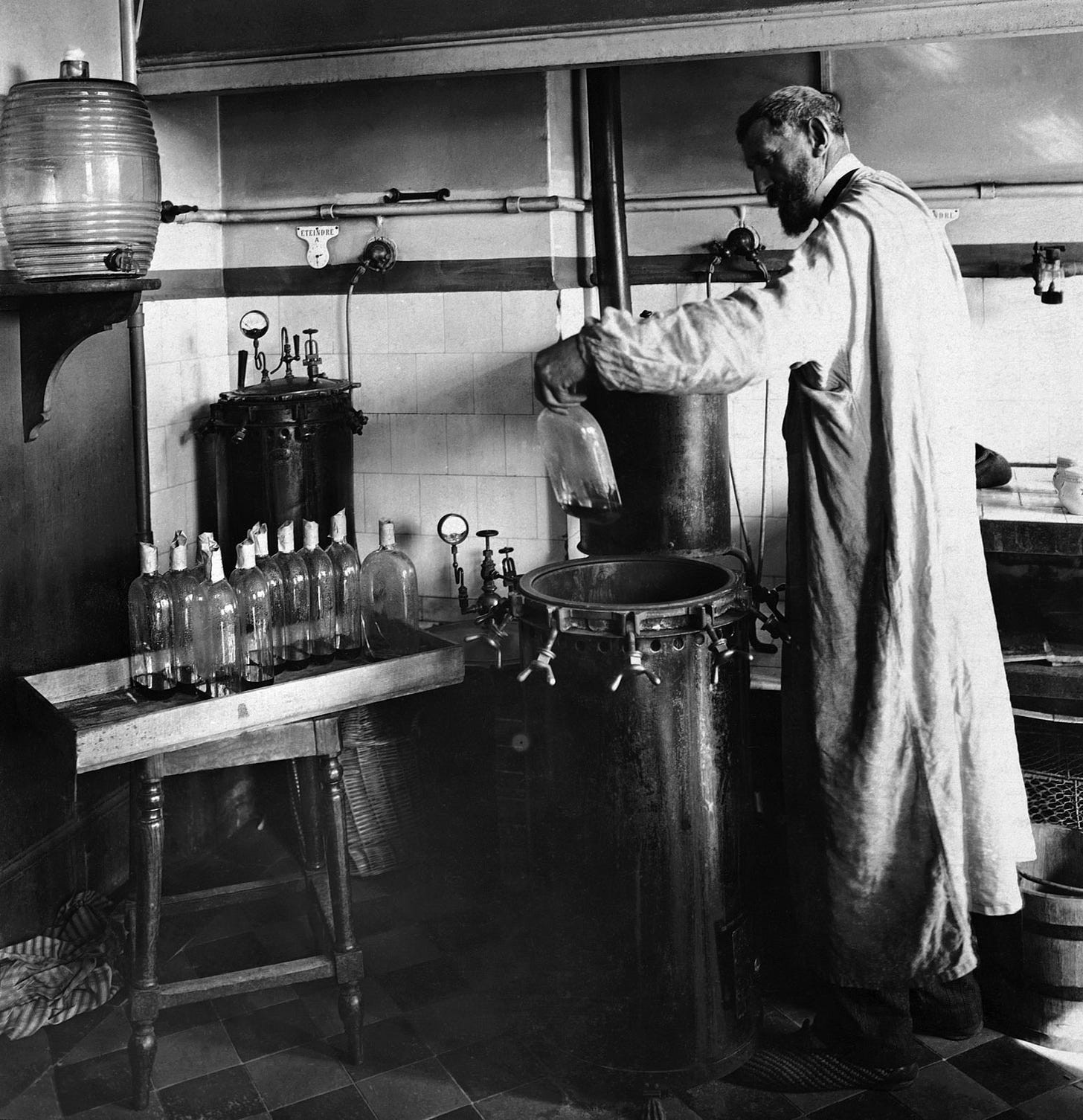 A man in a long coat stands in a laboratory, pouring liquid into a large container, surrounded by glass bottles and laboratory equipment. A man in a long coat stands in a laboratory, pouring liquid into a large container, surrounded by glass bottles and laboratory equipment.