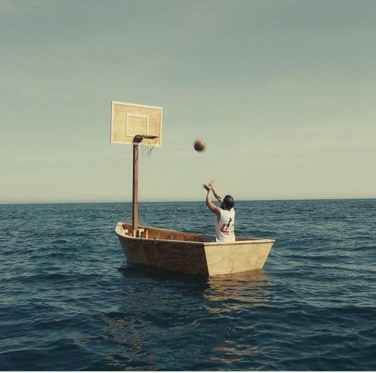 This may contain: a man in a boat throwing a basketball into the air