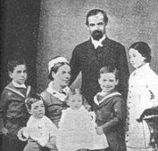 A British missionary family, an indigenous Yahgan family, and houses with fences overshadowed by mountains