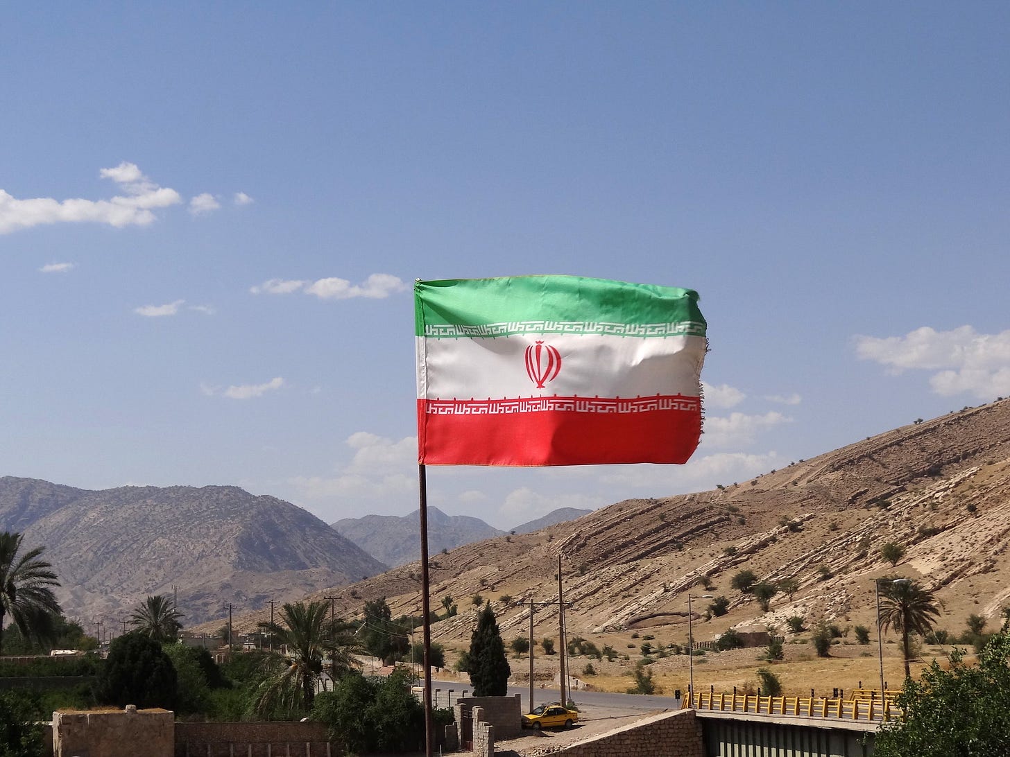 An Iranian flag flies in a mountain scene An Iranian flag flies in a mountain scene