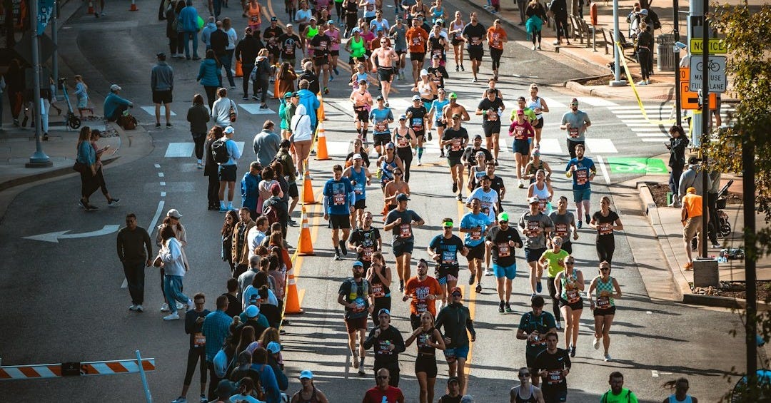 a large group of people running down a street a large group of people running down a street