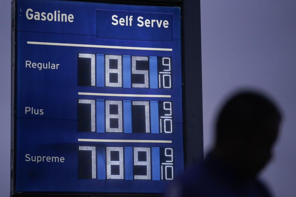FILE - High gas prices are shown as a pedestrian waits to cross the street in Los Angeles, June 16, 2022. President Joe Biden on June 22 will call on Congress to suspend the federal gasoline and diesel taxes for three months. It's a move meant to ease financial pressures at the pump that also reveals the political toxicity of high gas prices in an election year.(AP Photo/Jae C. Hong, File)